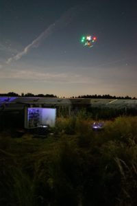 Drone-based aerial inspection being performed at night on a solar farm.